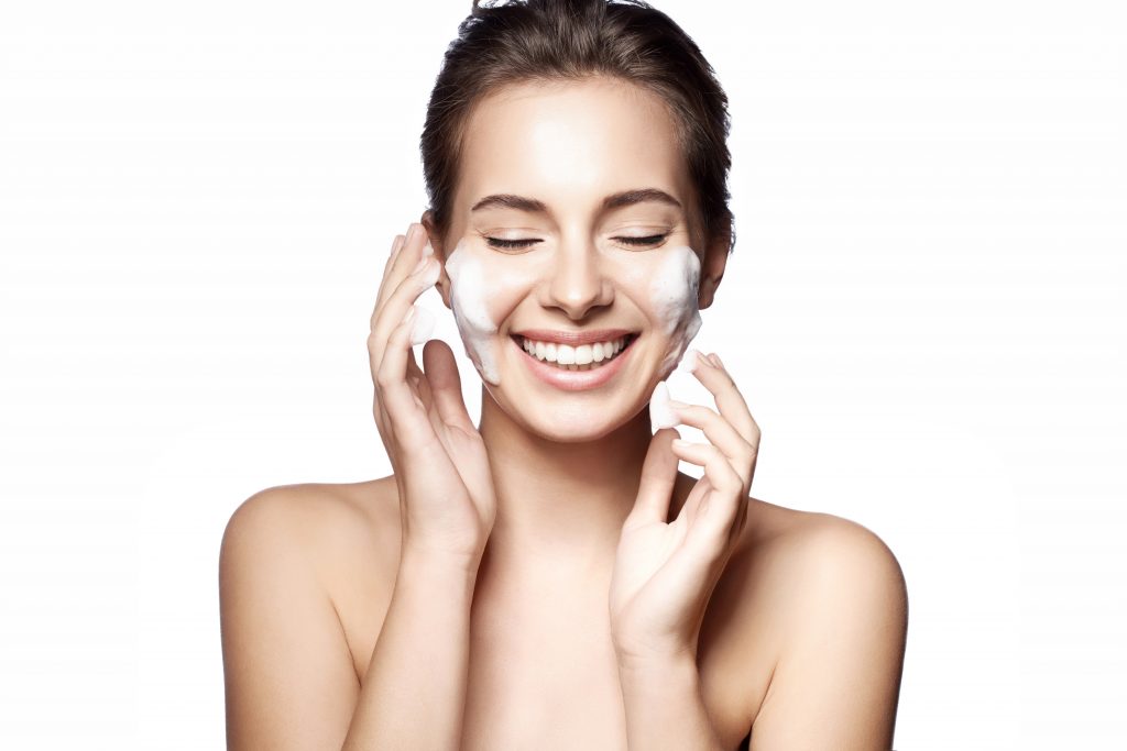 Woman happily cleanses the skin